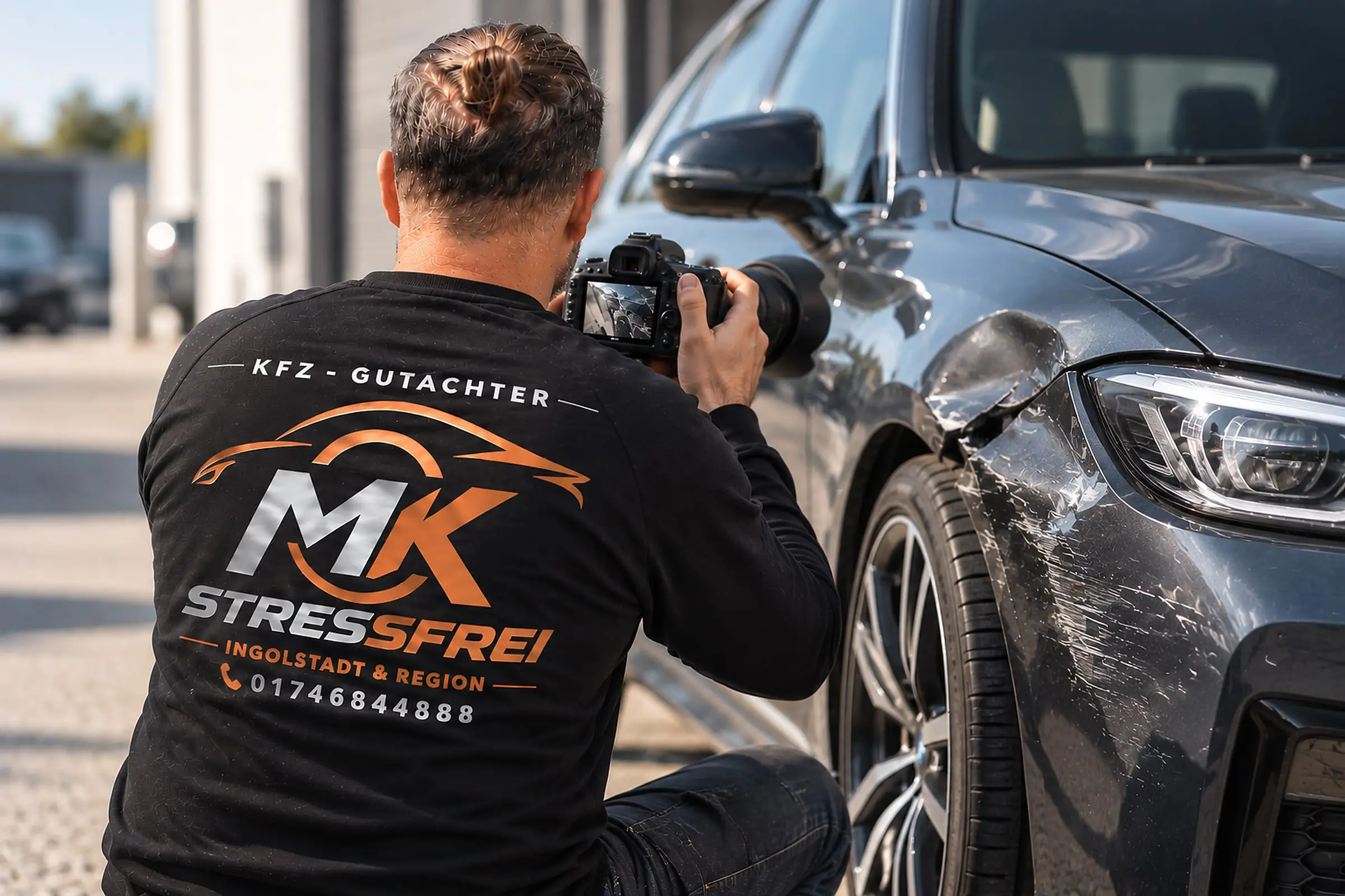 Kumalic Mersum fotografiert den Unfallschaden an einem Fahrzeug, auf dem Rücken das Logo von MK Stressfrei